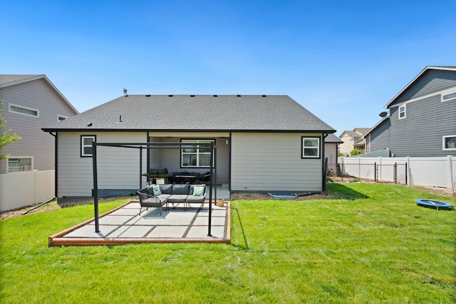 Finished backyard patio with green lawn